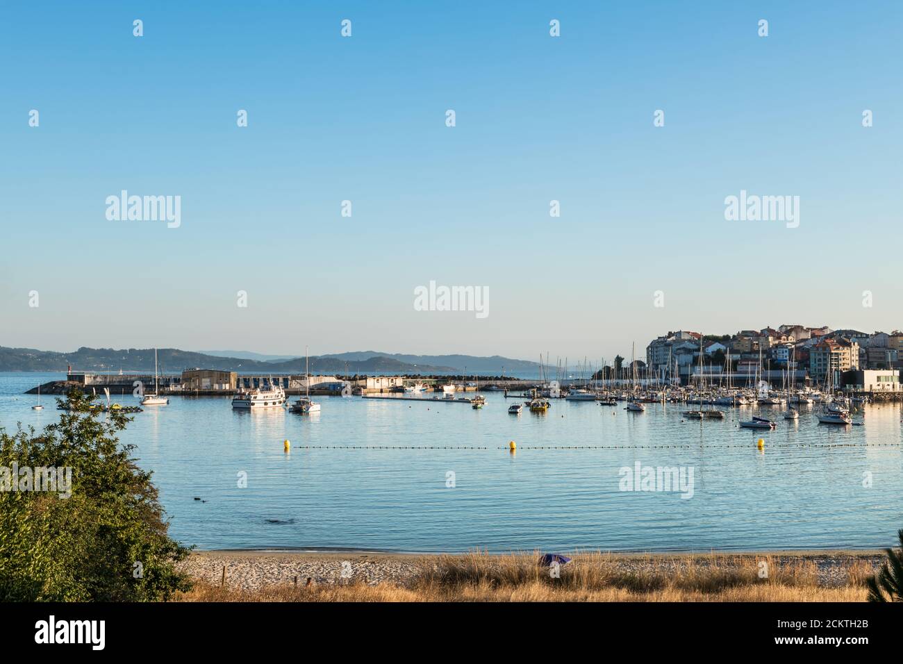 Wide-angle view of the beach and sport port of Portonovo in the Ria de Pontevedra at dusk, Spain. Stock Photo