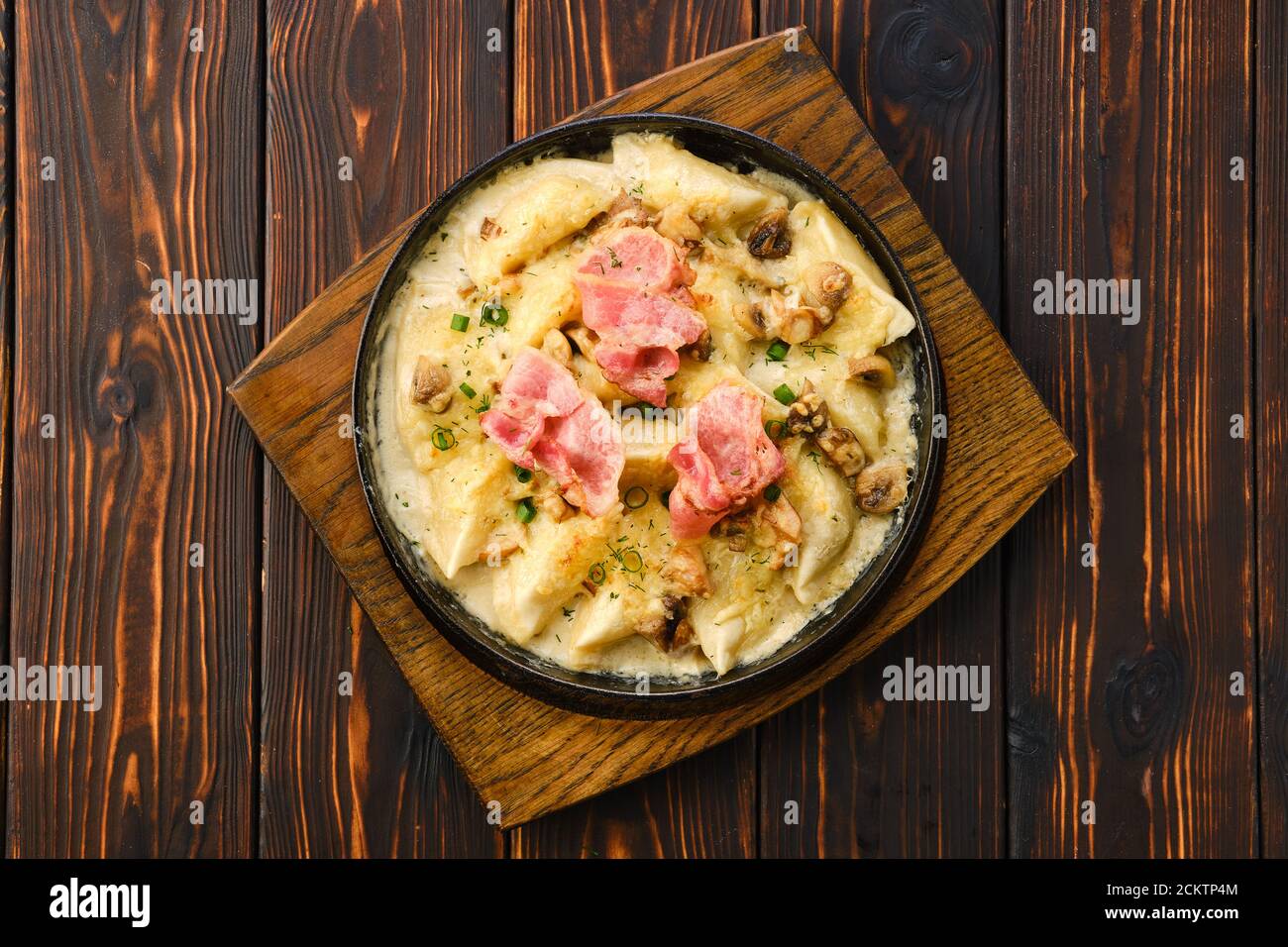 A close up view of bacon sizzling in the frying pan on a stovetop. Cooking  bacon slices for breakfast fry up Stock Photo - Alamy