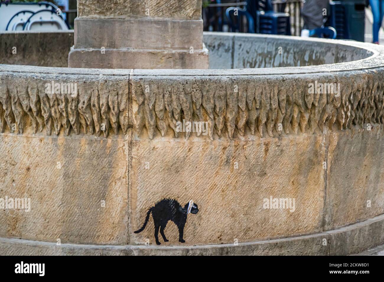 Titus the black cat with toothache as graffito on a fountain in Dole, France Stock Photo