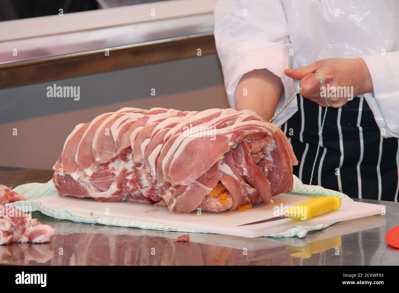 A Butcher Using String to Tie Together a Joint of Meat Stock Photo - Alamy