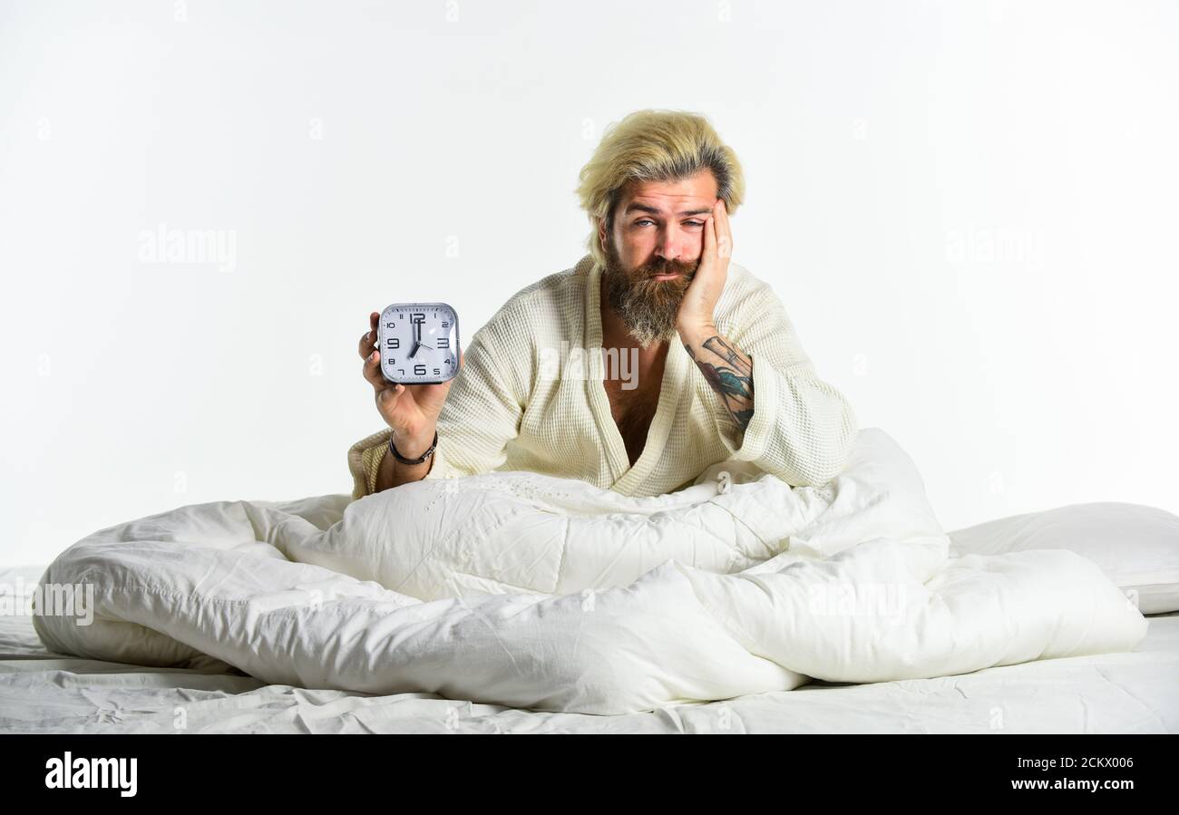 Bearded man with alarm clock. Awakening. Sleep complex biological