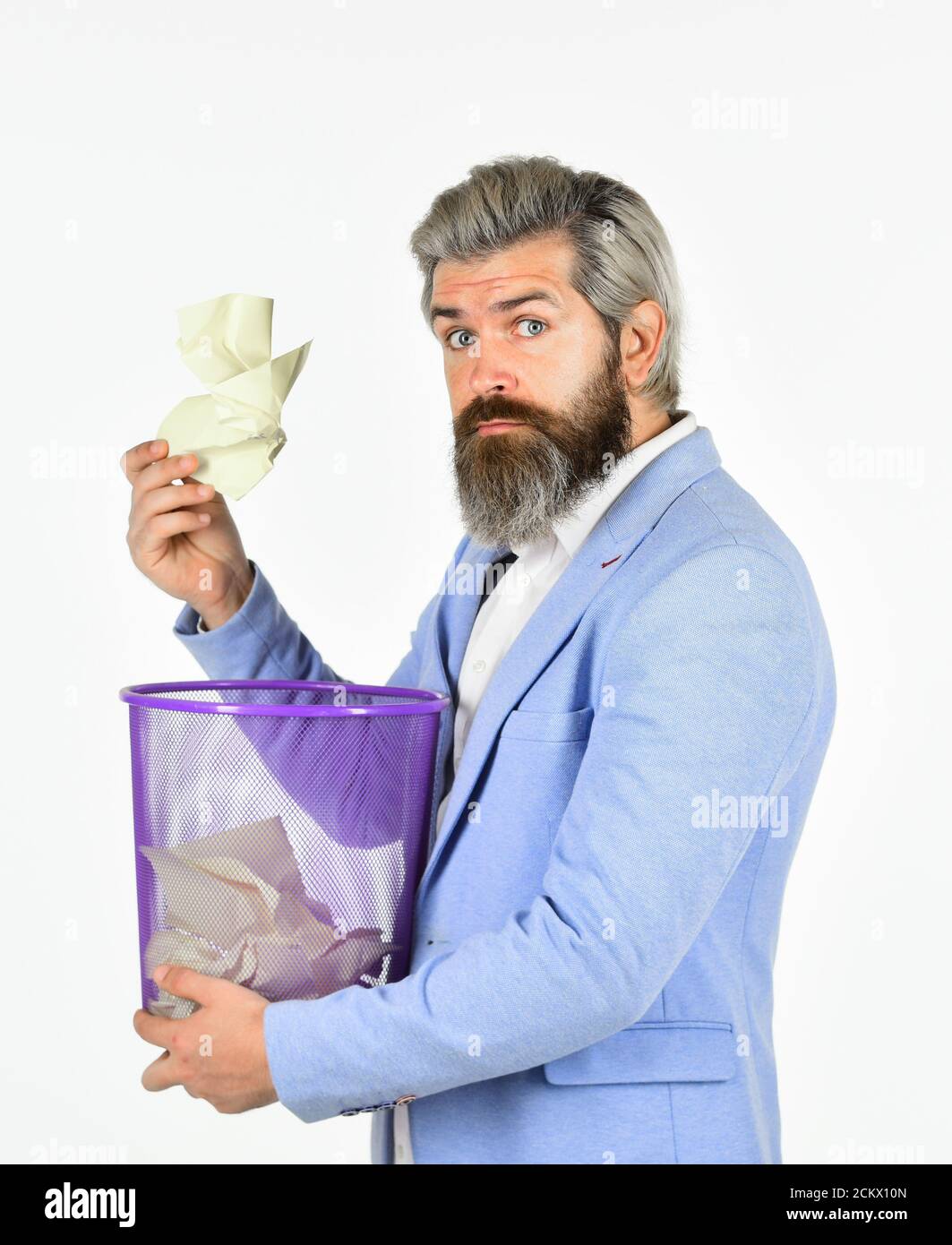 Destroy evidence. Man look for lost document in paper bin. Office worker digging in garbage bin. Recover document. Insure important documents. Recover files after deletion. Businessman hold trash can. Stock Photo