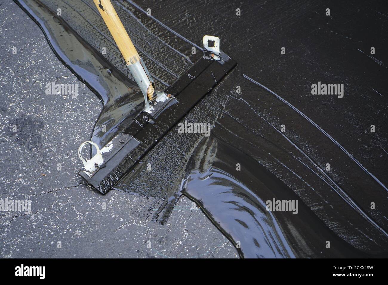 Man sealing asphalt driveway/Sealcoating Stock Photo Alamy