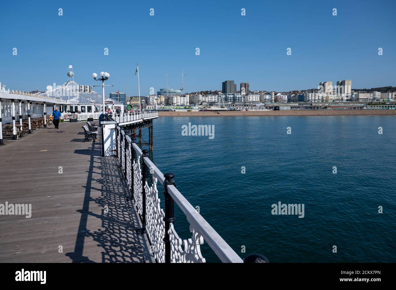 Brighton Seafront view from Palace Pier on a warn and sunny day with tourist enjoying a stroll along the pier. Stock Photo