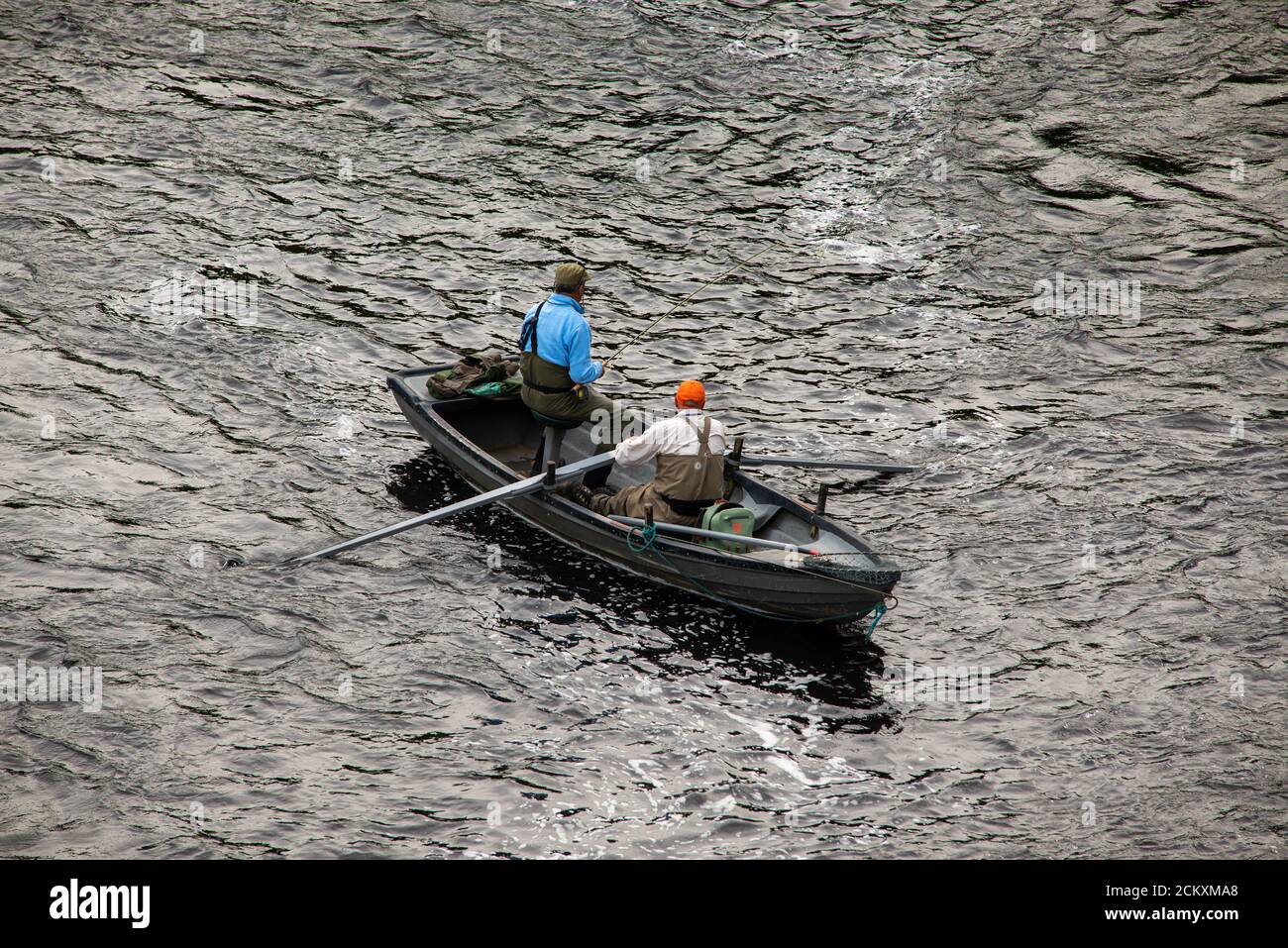 Boatman and rod fisher angling for salmon on the River Tweed at Kelso in the Scottish Borders. Stock Photo