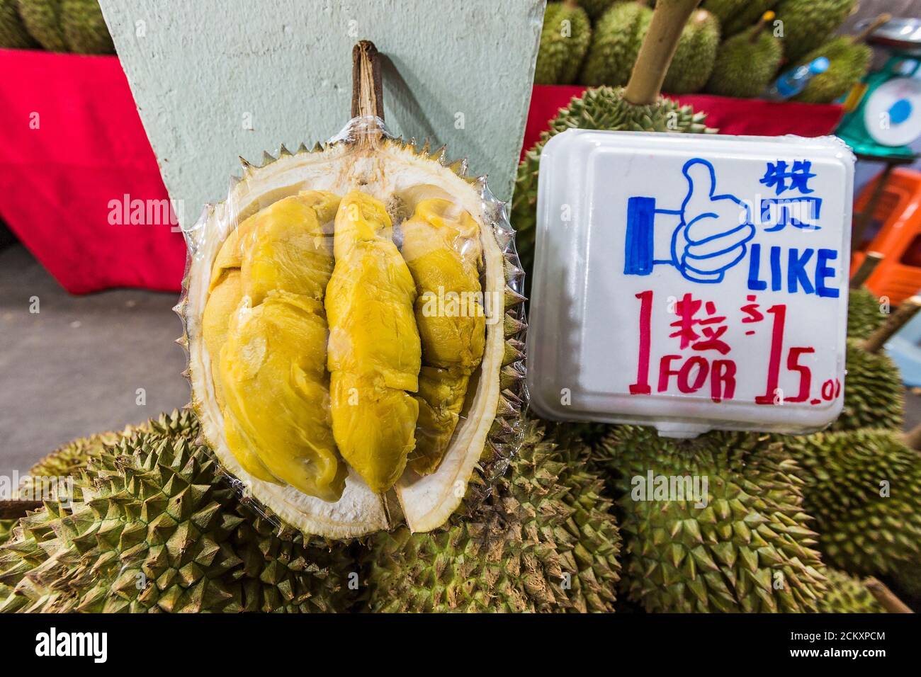 Famously smelly durian fruit, for sale at a night market in Singapore. The sickly sweet smell from this fruit is so intense, it is banned from some public transportation and hotels in tropical Asia. Stock Photo