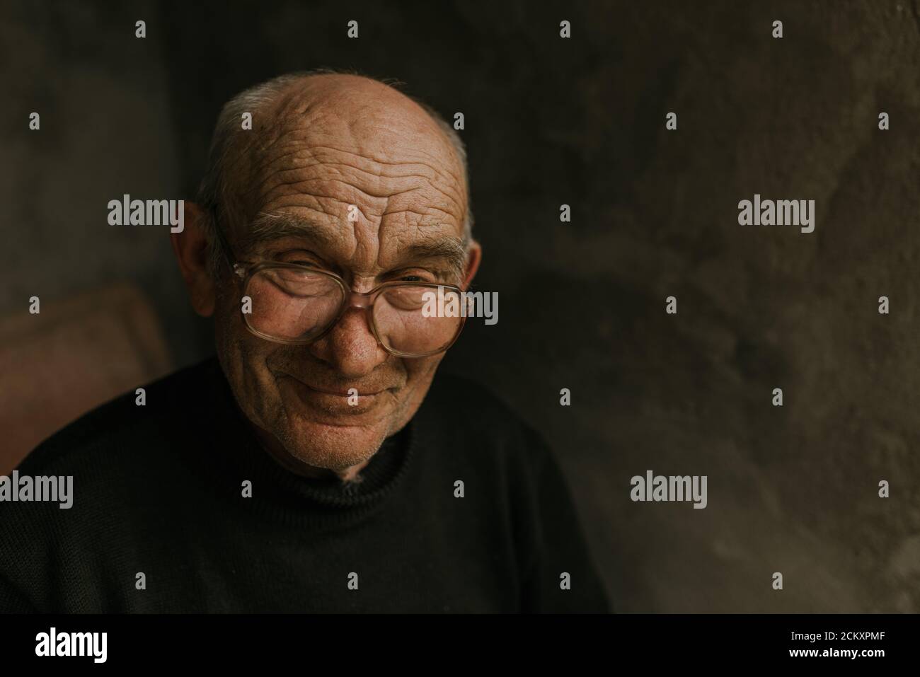 Pensive old man in glasses with gray hair Stock Photo