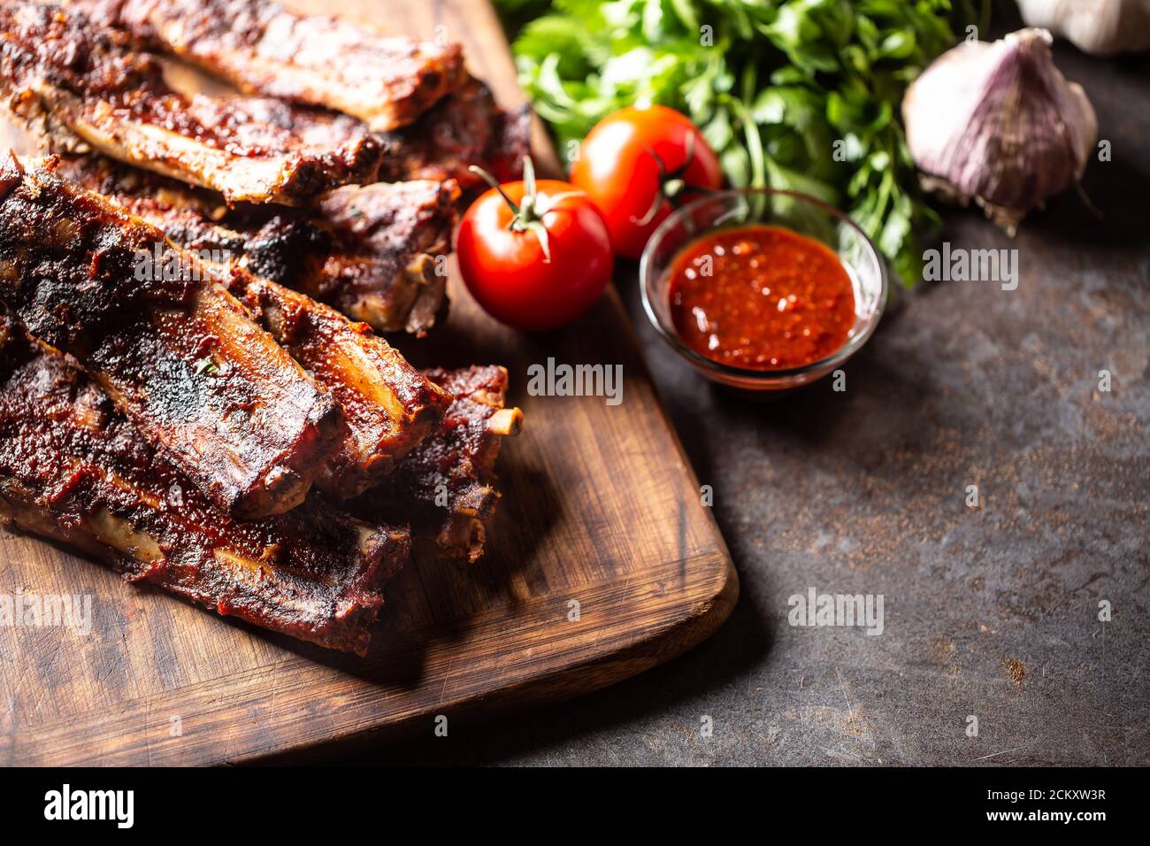 Baked glazed bbq ribs with a tomato sauce on the side Stock Photo