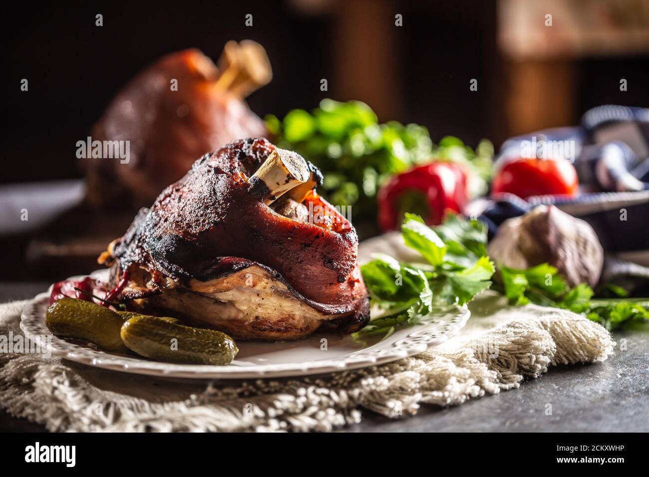 Smoked pork ham hock, pork knee served with pickled cucumbers and herbs Stock Photo