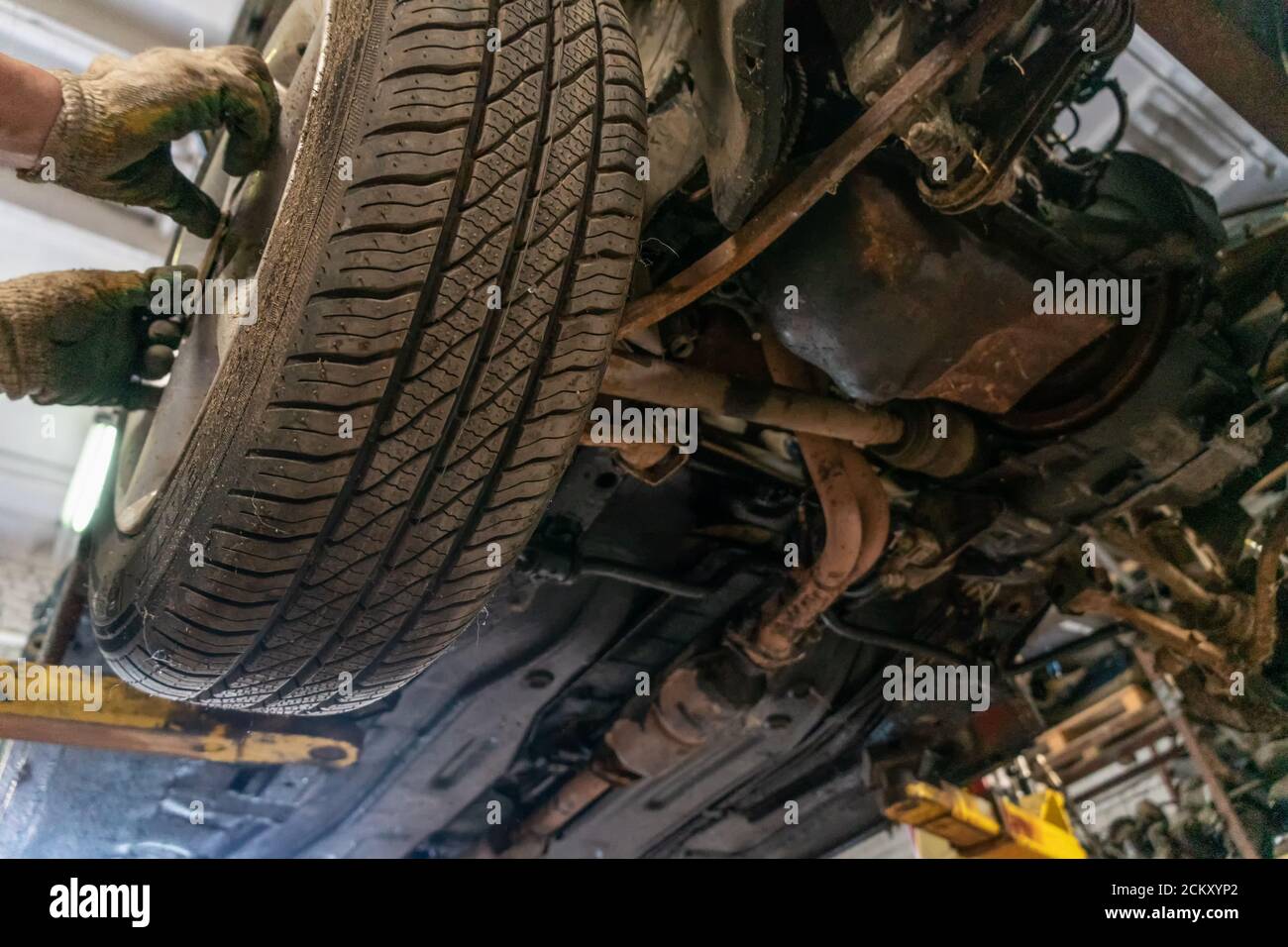 Mechanic with a wrench changes the wheels. Car service. Hands replace the tires on the wheels close up. The concept of the installation of the tires. Stock Photo