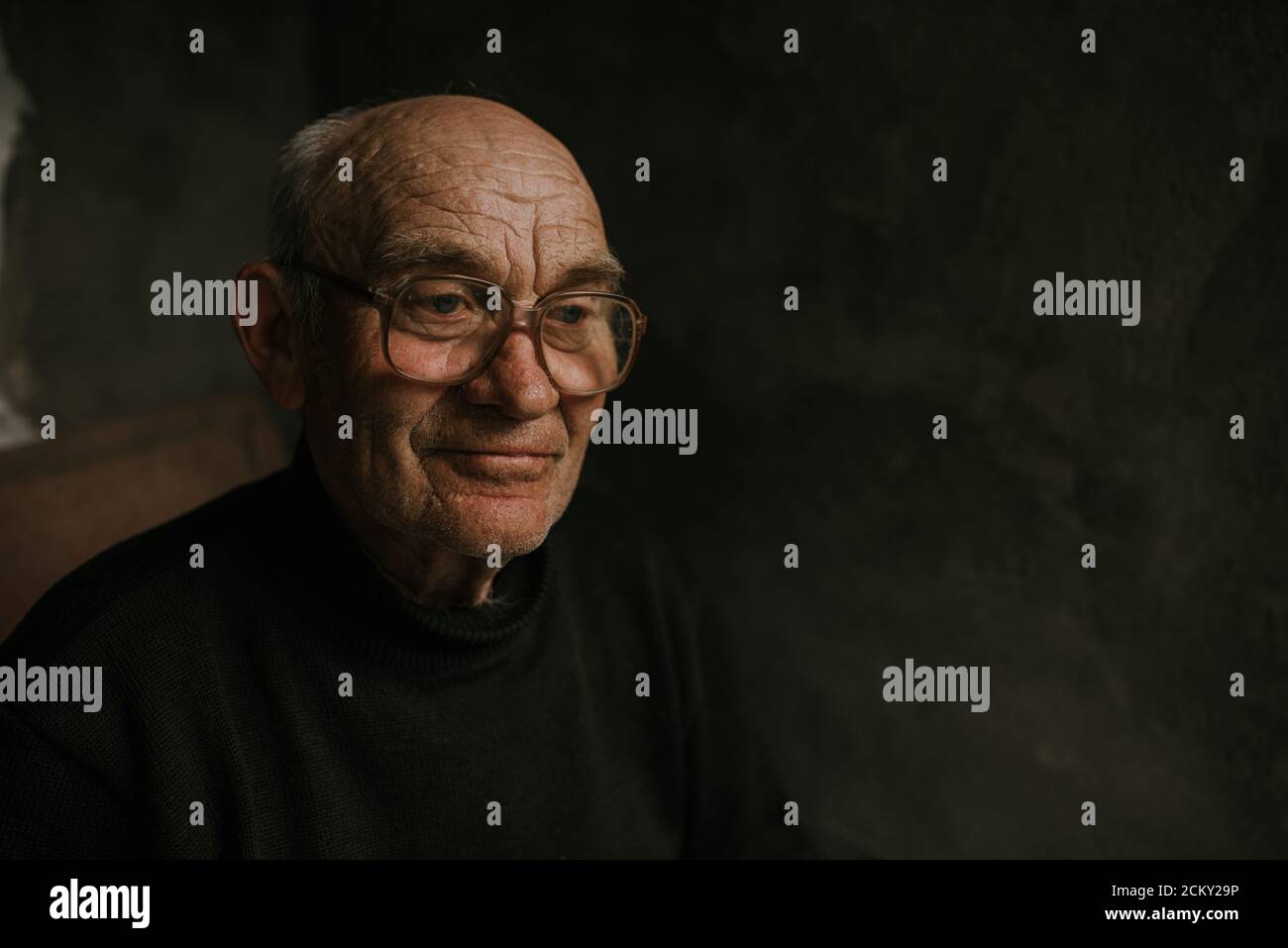 Pensive old man in glasses with gray hair Stock Photo