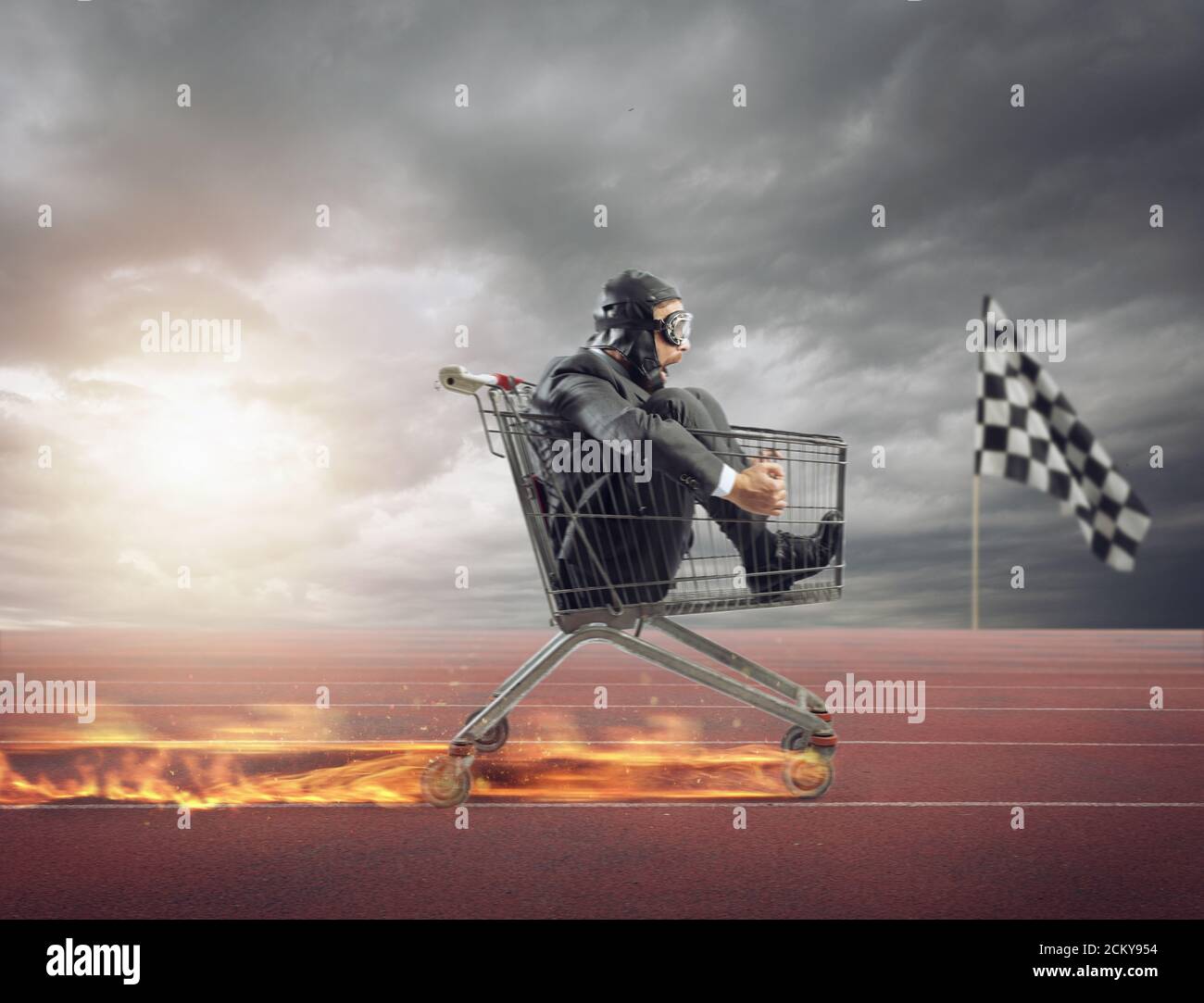 Businessman runs fast driving a cart on fire during a competition Stock Photo