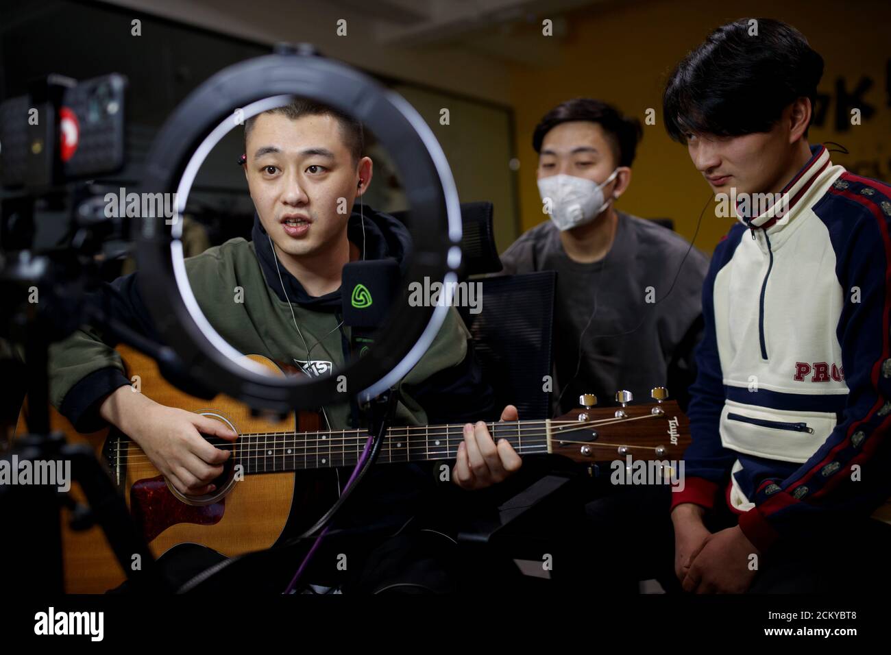 Musicians from the Chinese group 'The 2econd' Zhang Cheng, Zhuang Fei and Wen Zheng, perform for their fans during a live-streaming session broadcast on the video sharing website Bilibili at an office in Beijing, China, March 14, 2020. 'I see this period as a double-edged sword. Although some performance plans have been postponed, it gave us more time to cool down and reflect on our work and to make it more mature,' said Cheng. REUTERS/Thomas Peter     SEARCH 'COVID-19 LIFE ONLINE' FOR THIS STORY. SEARCH 'WIDER IMAGE' FOR ALL STORIES. Stock Photo