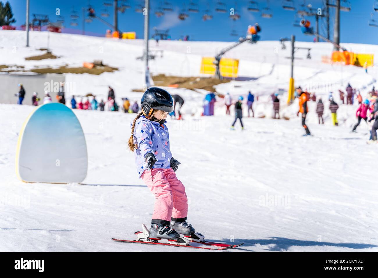 Young happy skier girl learning how to ski on the green ski zone. Young skier having fun on ski slope, Bialka Tatrzanska, Tatry, Poland Stock Photo