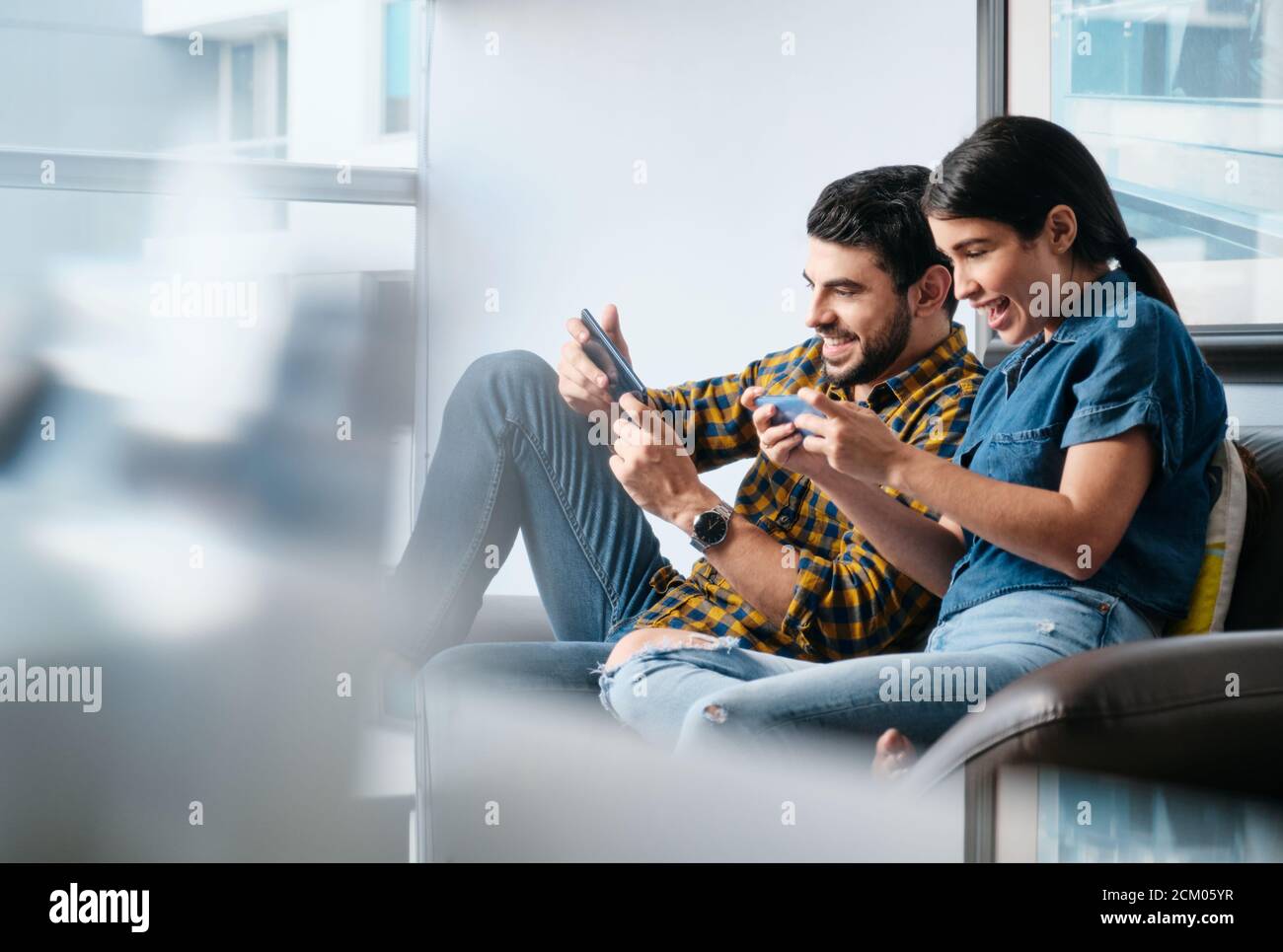 Happy People Playing Video Game With Smartphone And Laughing Stock Photo