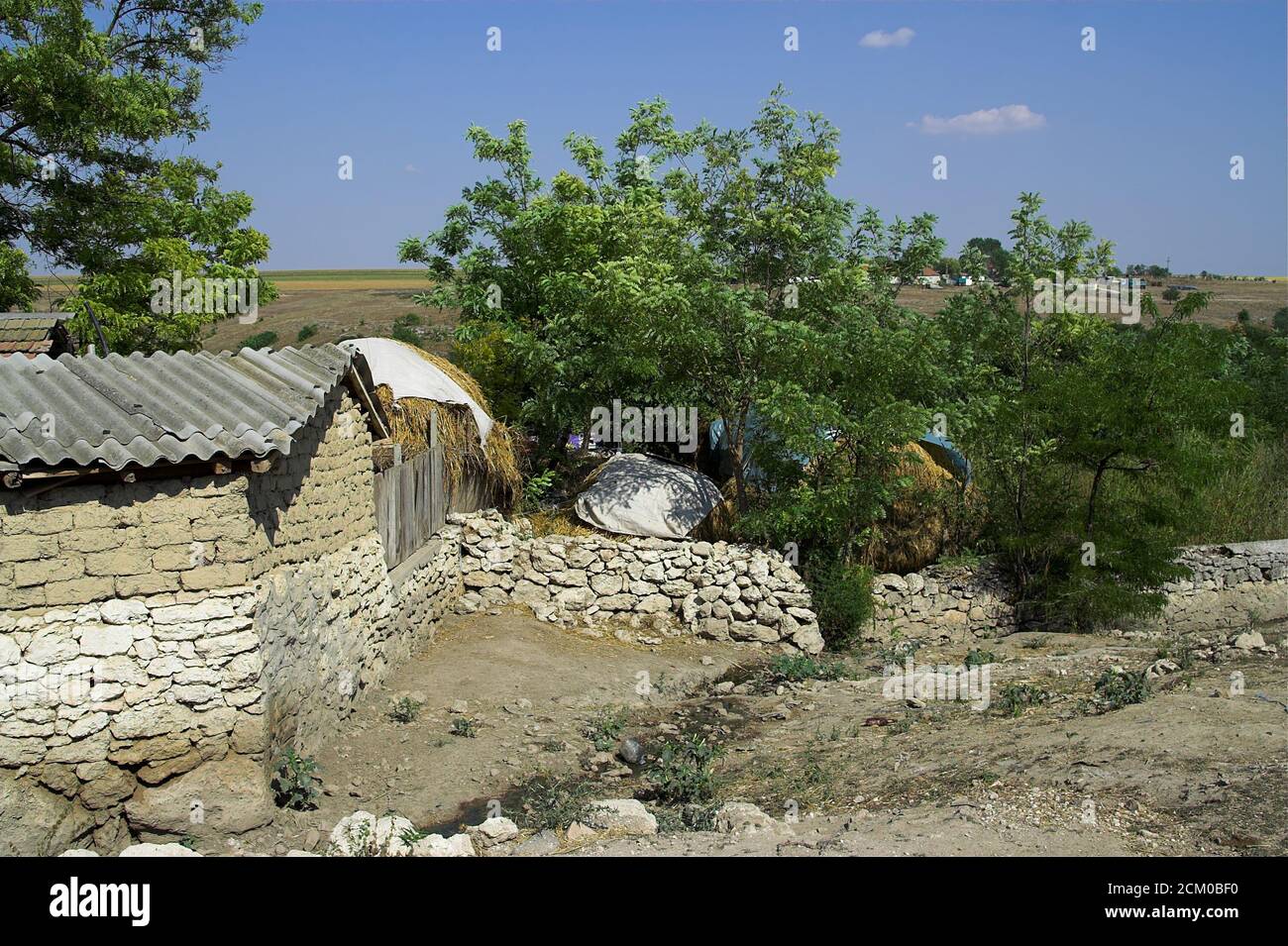 View of farm buildings in a poor provincial Romanian village. Ansicht von Wirtschaftsgebäuden in einem armen rumänischen Provinzdorf. Stock Photo