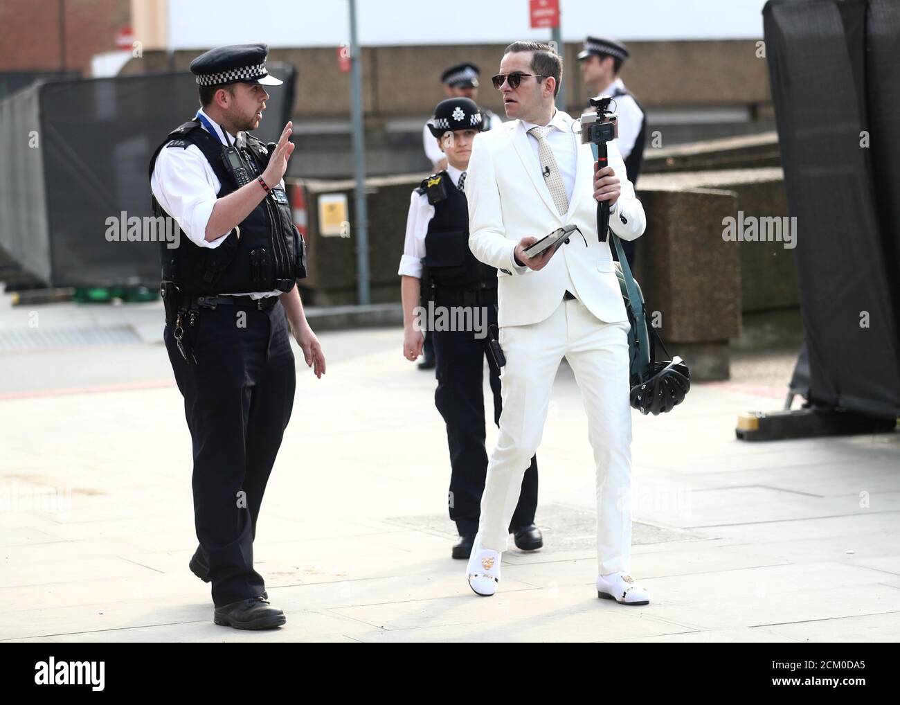 Police officers speak with a man who was preaching outside St Thomas' hospital as the spread of the coronavirus disease (COVID-19) continues, London, Britain, April 8, 2020. REUTERS/Simon Dawson Stock Photo