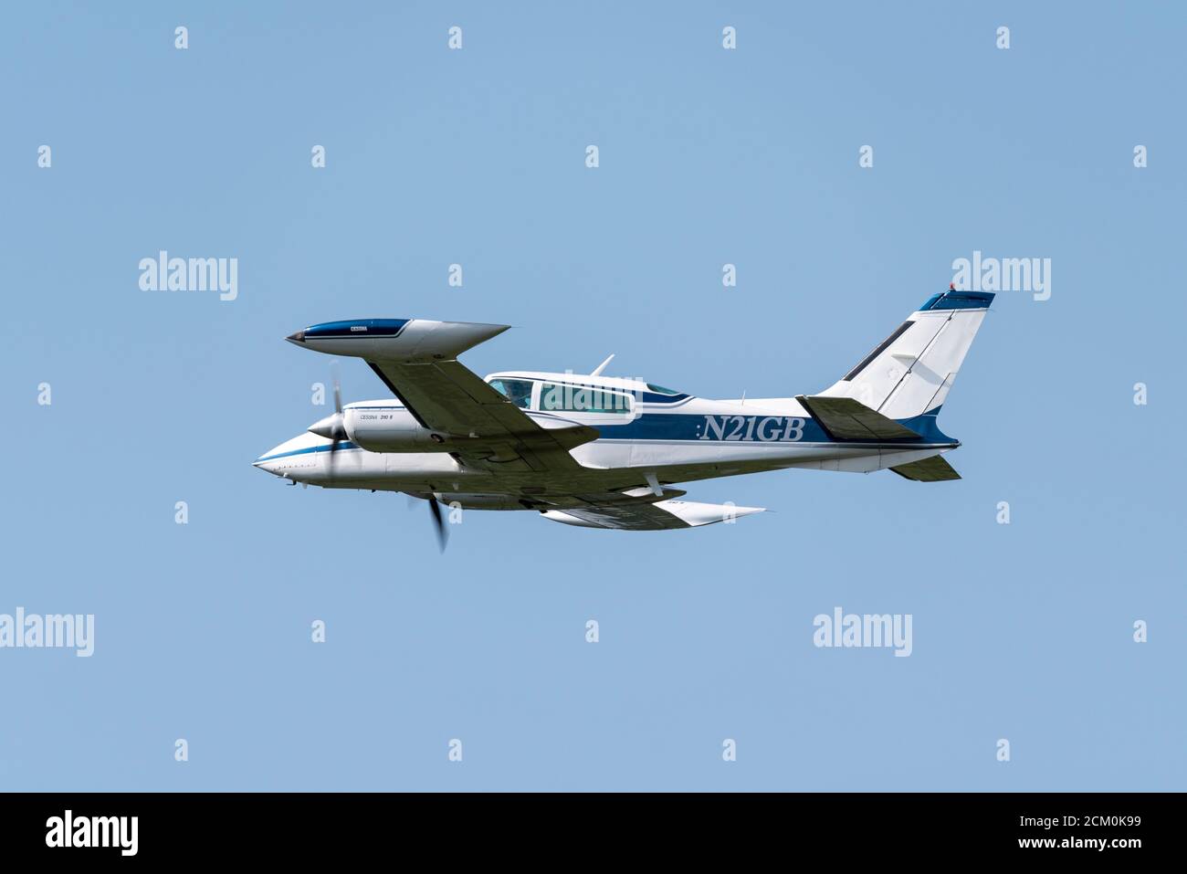 Cessna 310R twin propeller plane N21GB climbing away after taking off