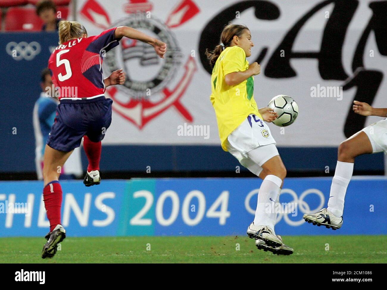 Tarpley of the U.S. scores past Brazil's Maycon during their gold medal match in women's Olympic soccer competition.  Linsay Tarpley of the U.S. (L) shoots past Brazil's Maycon to score during their gold medal match in the women's soccer competition at the Athens 2004 Olympic Games August 26, 2004. REUTERS/Max Rossi Stock Photo