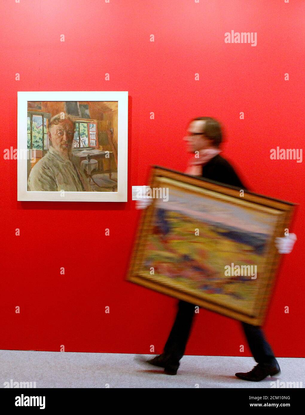 Hans-Peter Keller of Christie's Switzerland carries the painting 'Lueg'  from 1927 by late Swiss artist Cuno Amiet (1868-1961) during the  preparation of an exhibition before Christie's auctions in Zurich December  2, 2011.