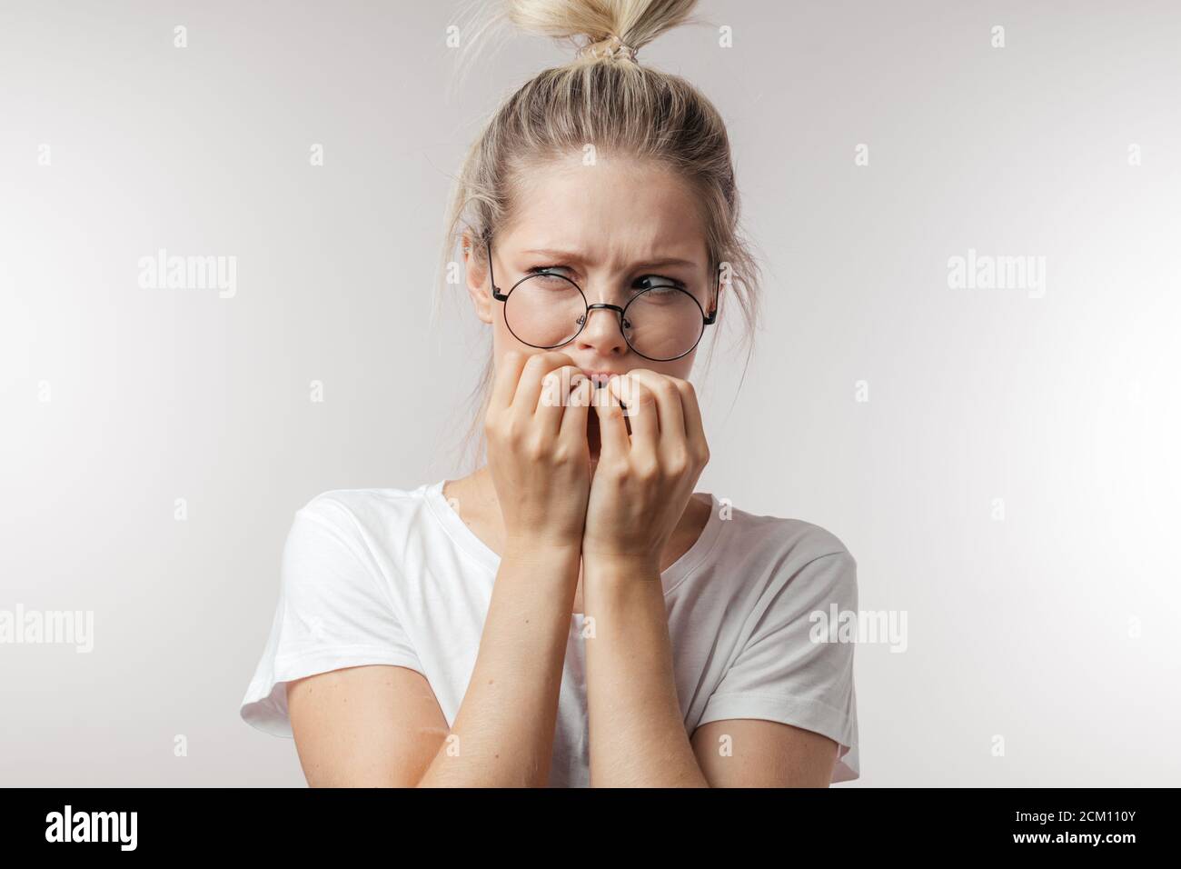 Portrait of offended unhappy beautiful woman holding hands near her mouth, ready to cry, displeased with everything, feels frustrated and upset. Negat Stock Photo