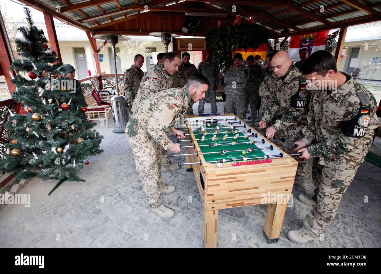 German Bundeswehr Military Police Play Foosball Next To A Christmas Tree,  As U.s. Military Police Comrades Watch, At The Army Camp In Kunduz,  Northern Afghanistan, December 7, 2010. Reuters/Fabrizio Bensch  (Afghanistan -