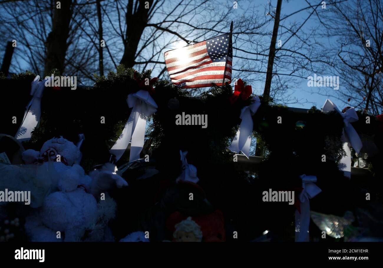 A flag that bears the names of the dead flies over a makeshift memorial in Sandy Hook, after the December 14 shooting tragedy when a gunman shot dead 20 students and six adults at Sandy Hook Elementary, in Newtown, Connecticut, December 28, 2012. REUTERS/Carlo Allegri  (UNITED STATES - Tags: CRIME LAW EDUCATION) Stock Photo