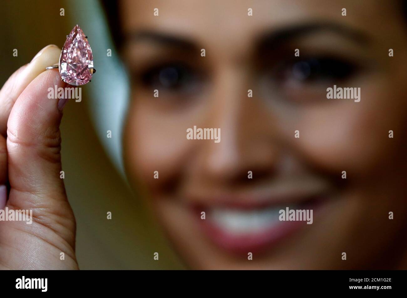 A model poses with 'The Unique Pink' diamond mounted during a preview at Sotheby's auction house in Geneva, Switzerland May 9, 2016. The supremely rare and exceptional Fancy Vivid Pink diamond, weighting 15.38 carats, is estimated to sell for US $ 28 to 38 million, when auctioned during the Magnificent Jewels and Noble Jewels auction in Geneva on May 17. REUTERS/Denis Balibouse Stock Photo