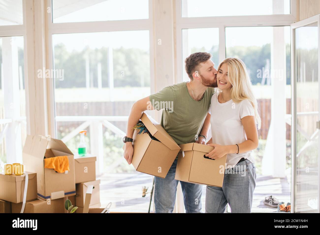 Happy young Couple Carrying Cardboard Boxes Into New Home On Moving Day ...