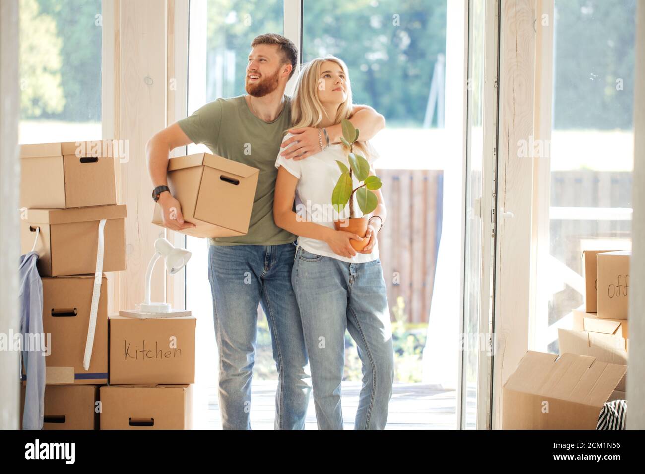 Happy young Couple Carrying Cardboard Boxes Into New Home On Moving Day ...