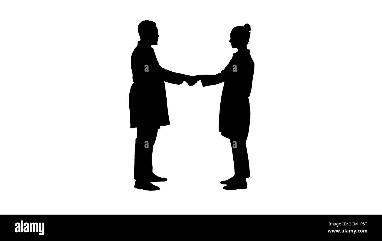 Silhouette Two young doctor shaking hands. Stock Photo