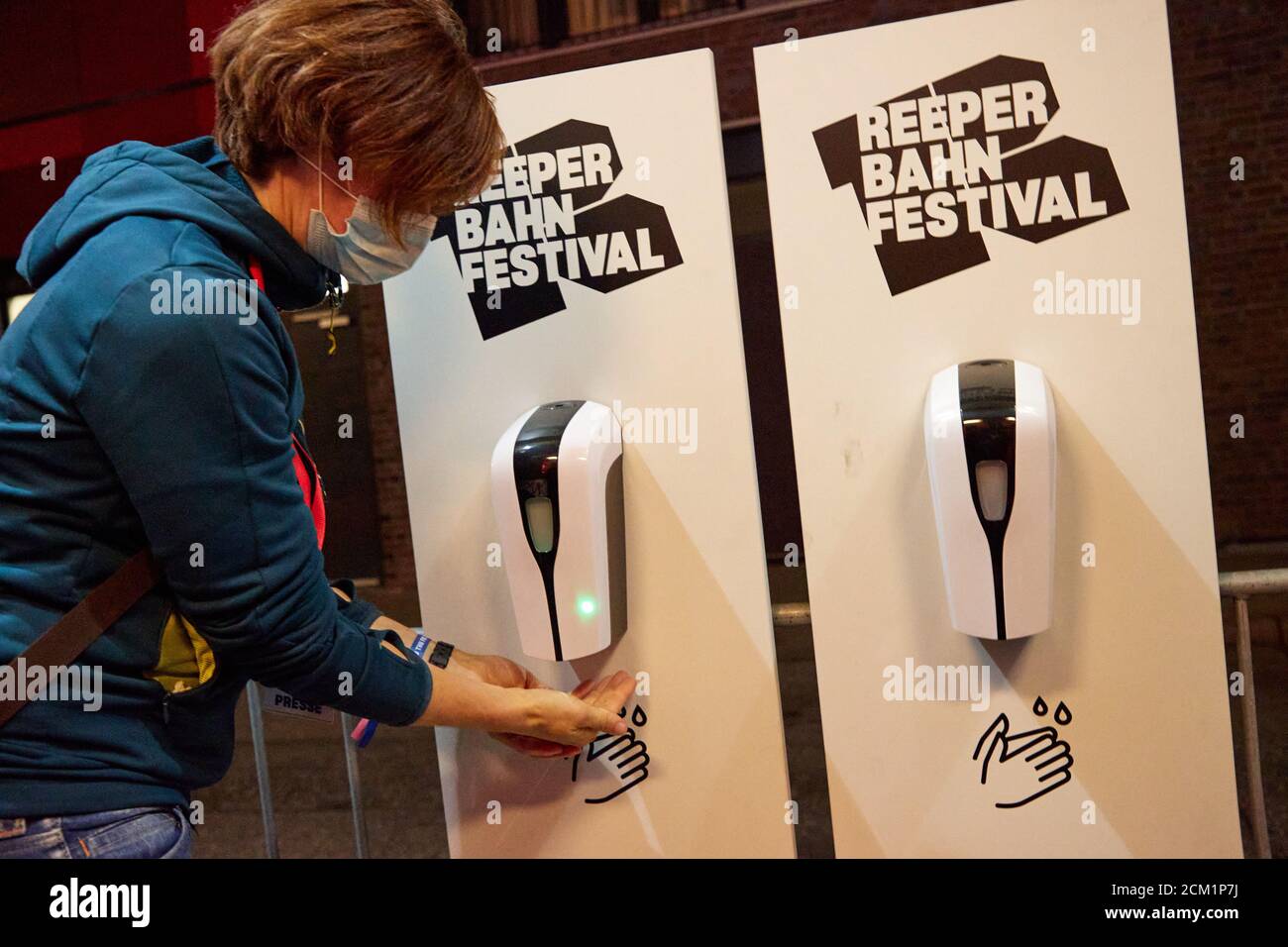 Hamburg, Germany. 16th Sep, 2020. A concert visitor disinfects her hands at a dispenser in front of the entrance to the Grünspan. Credit: Georg Wendt/dpa/Alamy Live News Stock Photo