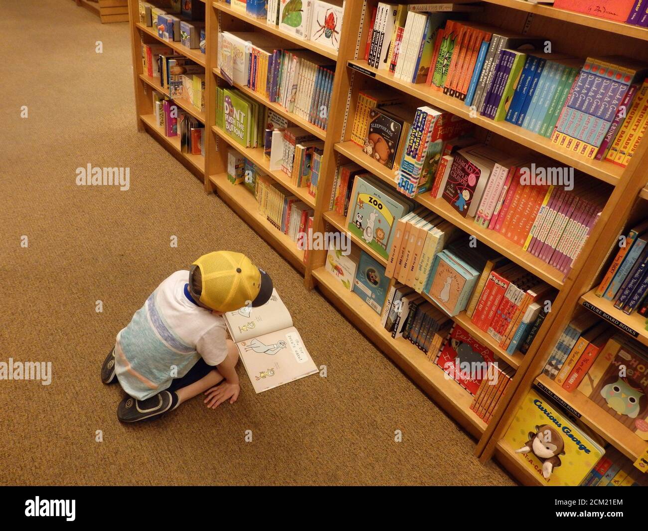 A young boy reading a book on the floor. Stock Photo