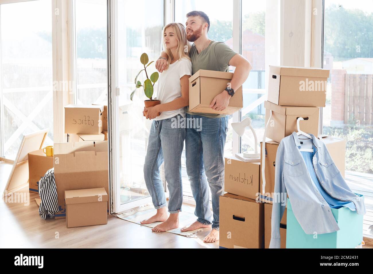 Happy young Couple Carrying Cardboard Boxes Into New Home On Moving Day ...