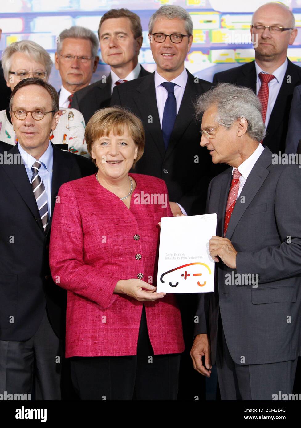 The head of the German Academy of Science Henning Kagermann (first row R) hands over the Second National Electromobility Report to German Chancellor Angela Merkel (first row R) at the Chancellery in Berlin May 16, 2011.  Also pictured are the head of the German Automobile Industry Association (VDA) Mattias Wissmann (first row L) and Environment Minister Norbert Roettgen (second row 2nd R) .   REUTERS/Thomas Peter (GERMANY - Tags: POLITICS) Stock Photo