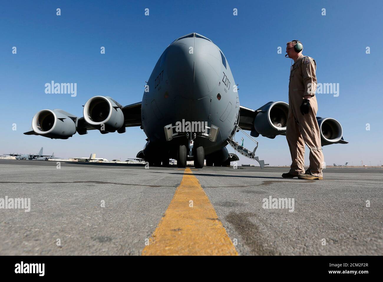 A British soldier stands in front of a Royal Airforce  C-17 Globemaster III aircraft at a Kandahar airfield, Afghanistan December 20, 2012. REUTERS/Stefan Wermuth (AFGHANISTAN - Tags: TRANSPORT MILITARY CONFLICT) Stock Photo