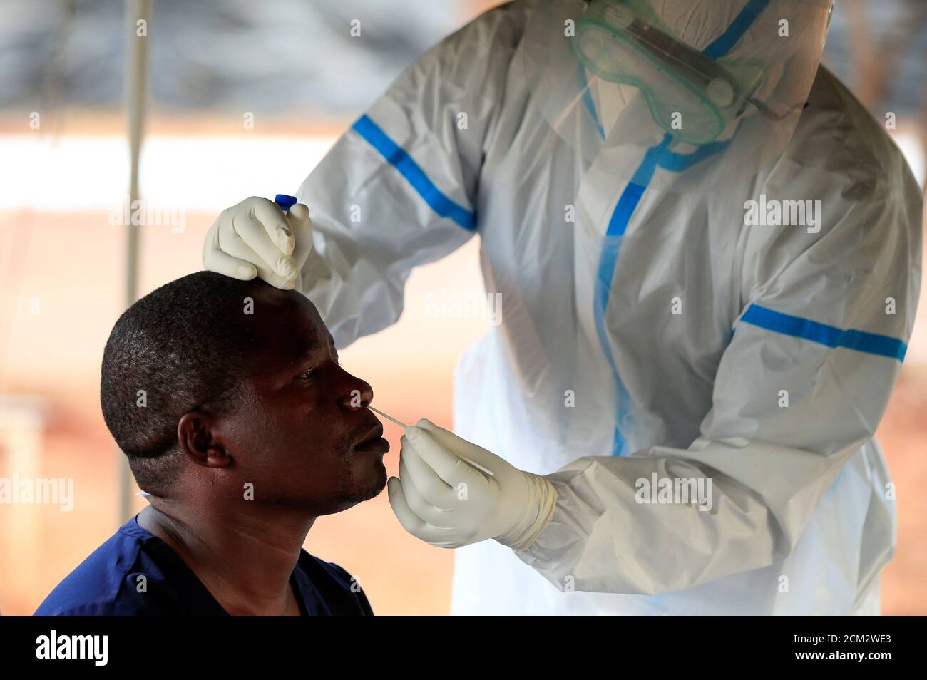 A man is tested by a healthcare worker during a nationwide lockdown to help curb the spread of the coronavirus disease (COVID-19), at a mass screening centre, in Harare, Zimbabwe April 30, 2020. REUTERS/Philimon Bulawayo Stock Photo