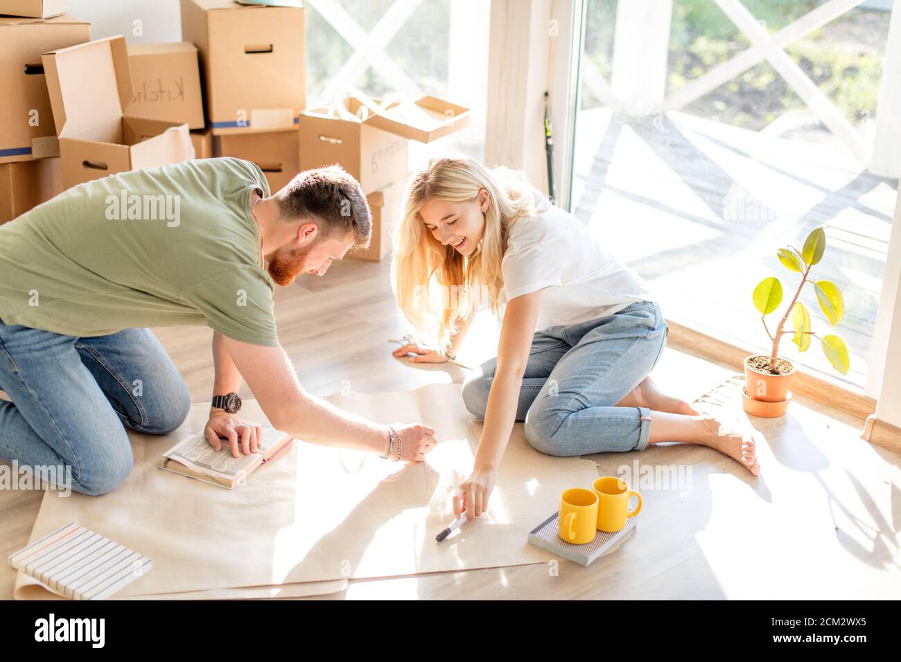 Portrait of happy caucsian couple planning new house design looking at paper Stock Photo