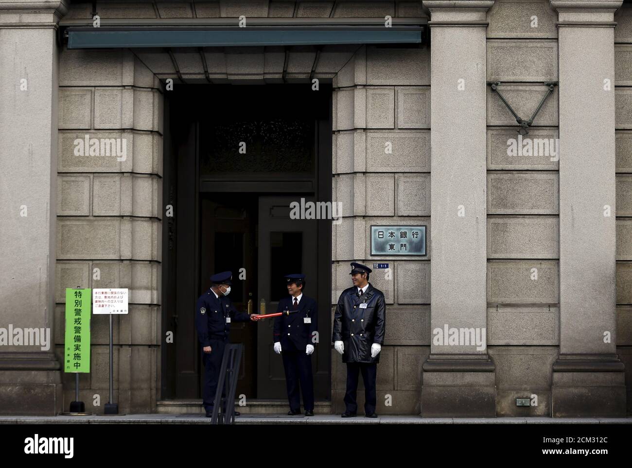 Security guards stand at an entrance of the headquarters of the Bank of Japan (BOJ) in Tokyo, Japan,  February 16, 2016. The Bank of Japan's negative interest rates came into effect on Tuesday in a radical plan already deemed a failure by financial markets, highlighting Tokyo's lack of options to spur growth as global markets sputter.  REUTERS/Thomas Peter Stock Photo