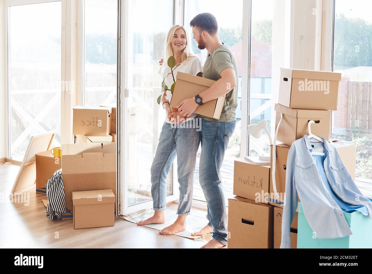 Happy young Couple Carrying Cardboard Boxes Into New Home On Moving Day ...