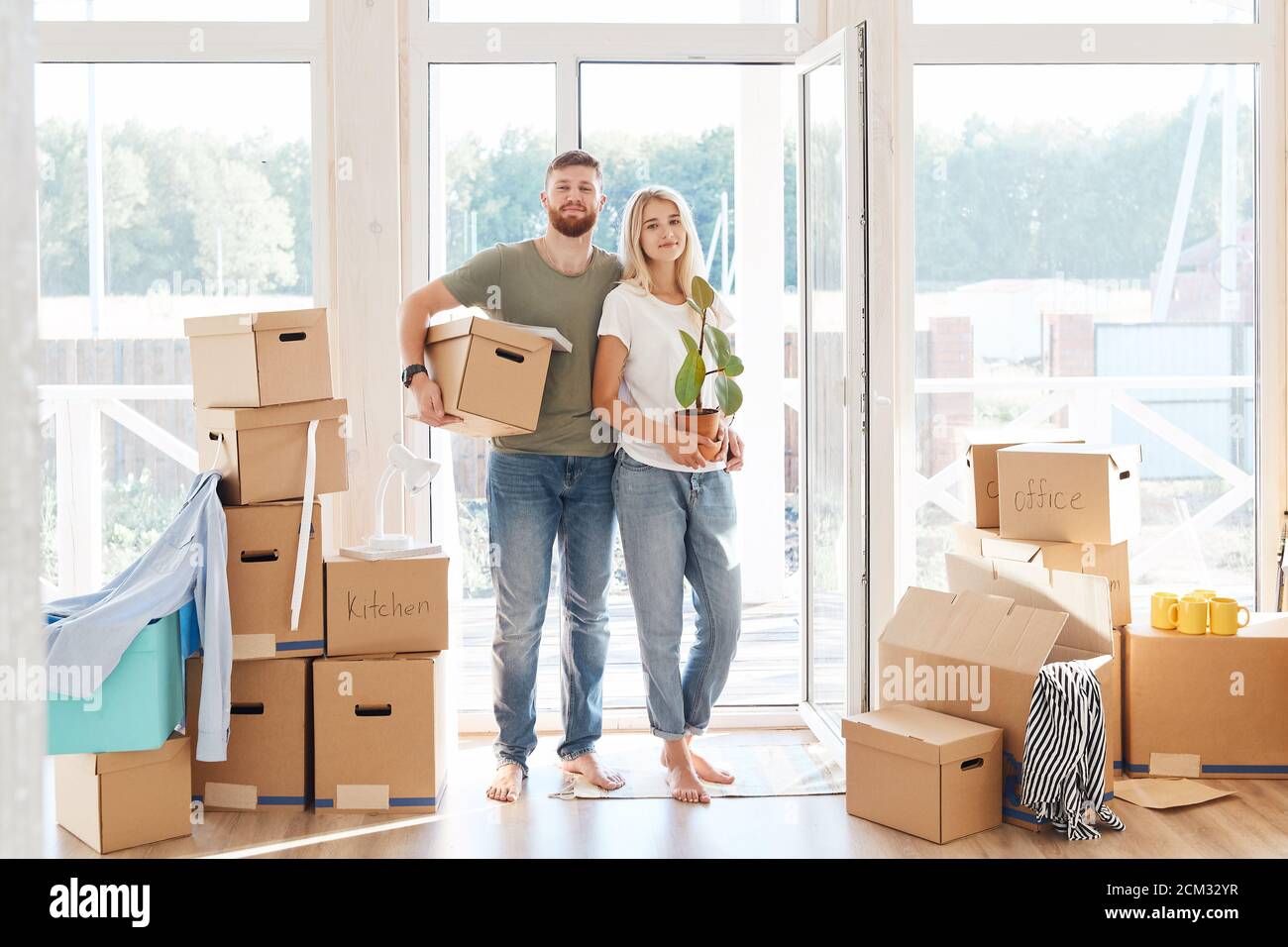 Happy young Couple Carrying Cardboard Boxes Into New Home On Moving Day ...