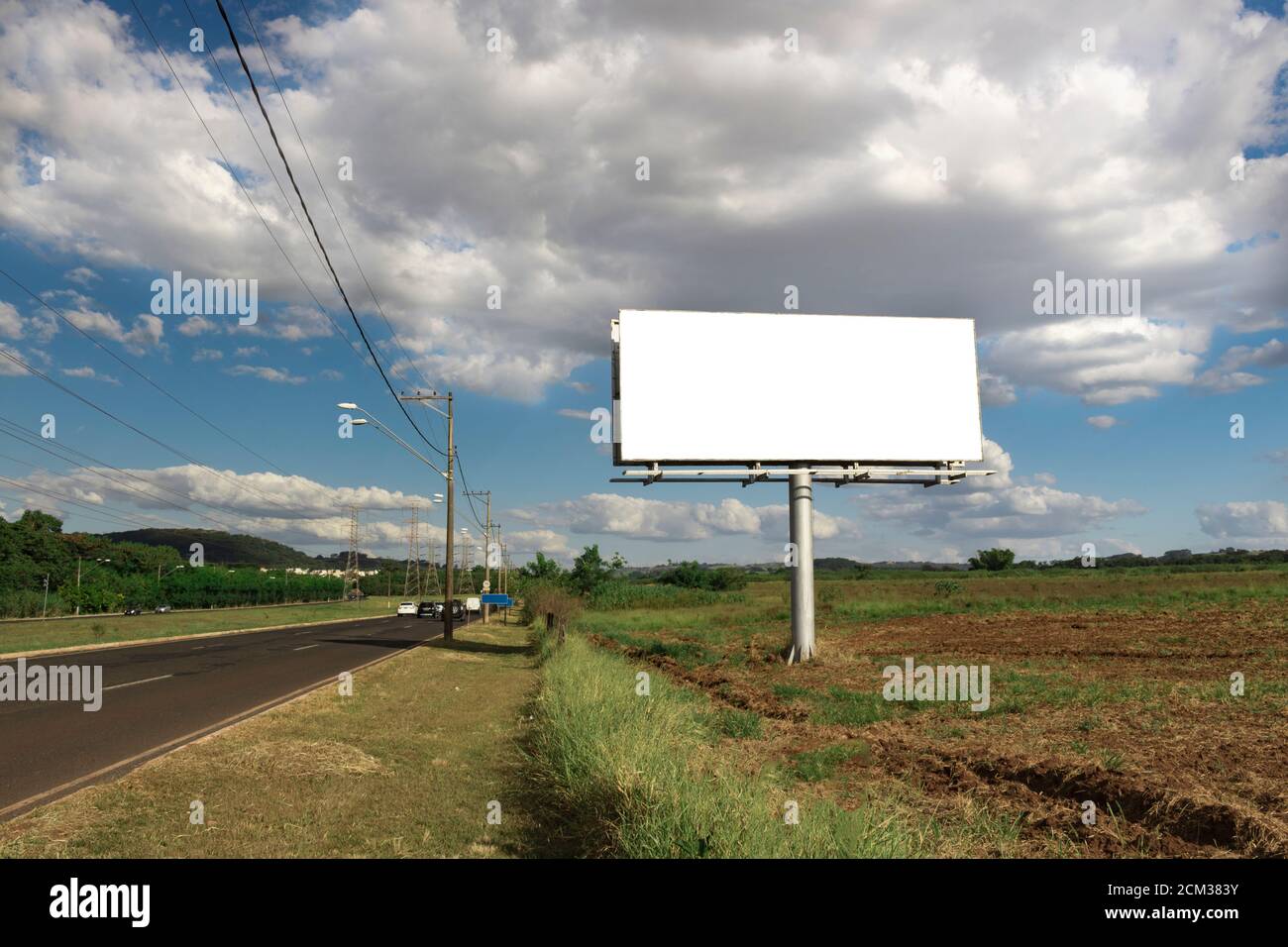 Billboard - Empty billboard in front of beautiful cloudy sky in a rural location. Space for text or design Stock Photo