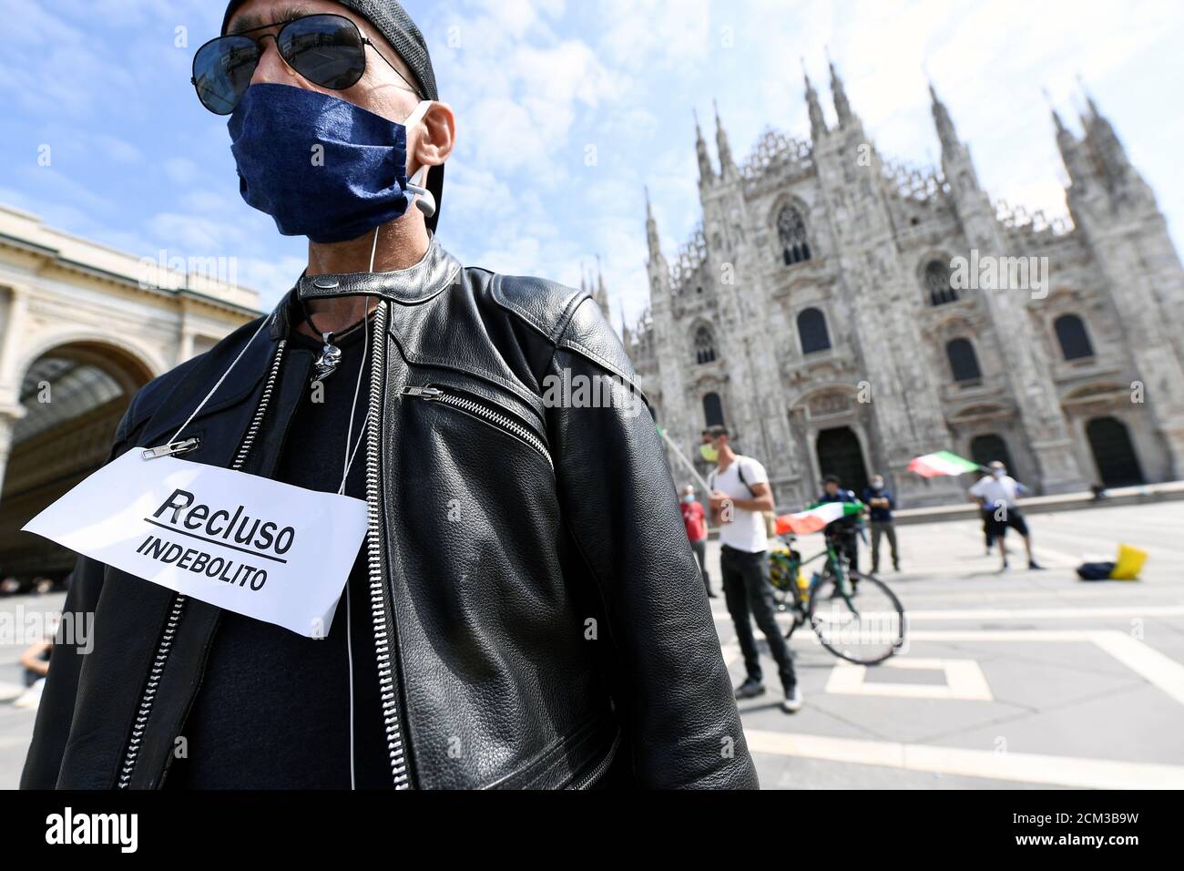 A protester wearing a protective mask and a sign attends a demonstration against the economic consequences of the lockdown at the Duomo square, as Italy begins a staged end to a nationwide lockdown due to a spread of the coronavirus disease (COVID-19), in Milan, Italy, May 4, 2020. Sign reads: 'Locked up. Weakened '. REUTERS/Flavio Lo Scalzo Stock Photo