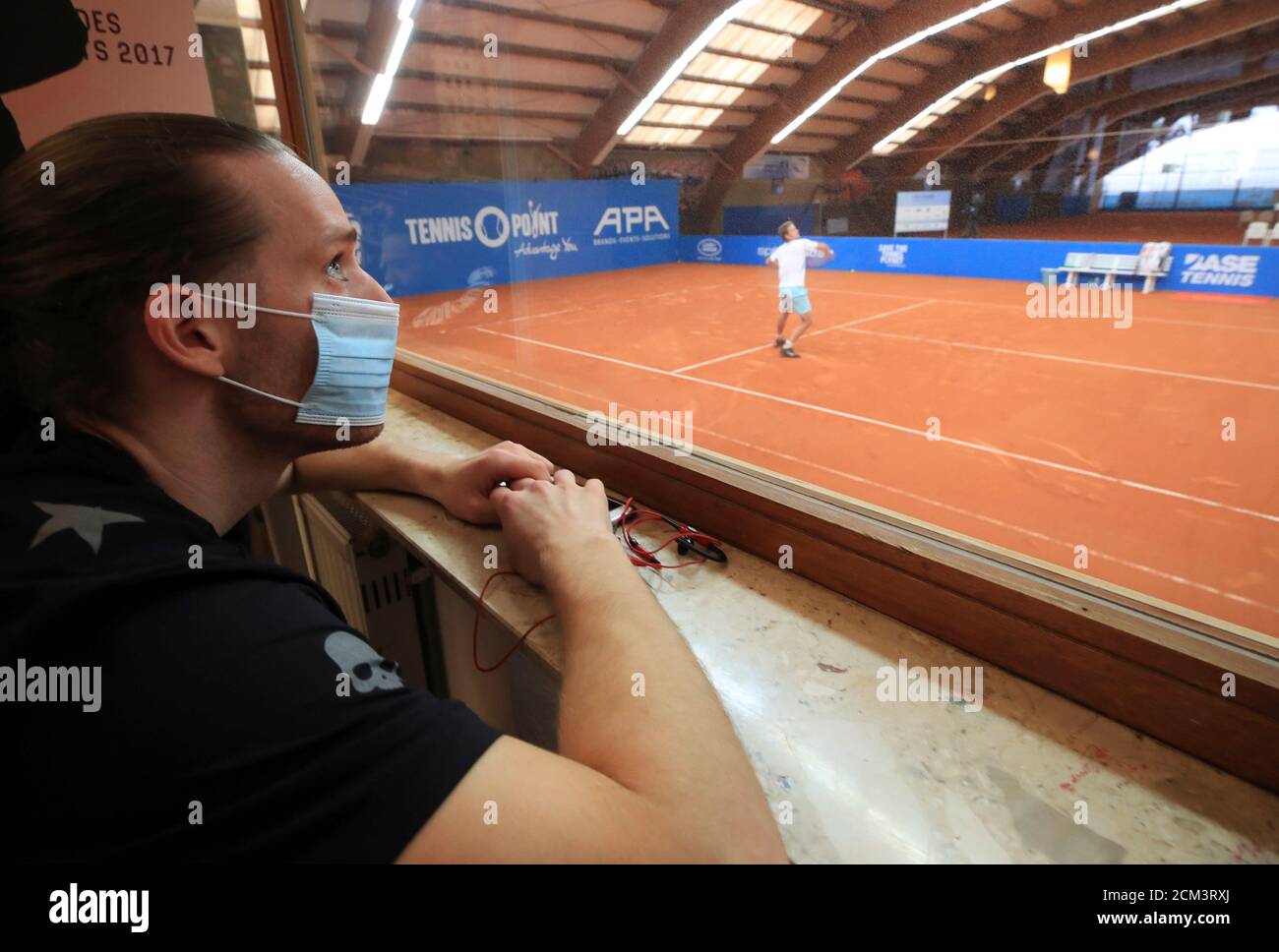 Jean-Marc Werner, a German tennis player of the ATP world tour, wears a  face mask as he watches his country fellow Johannes Haerteis playing in an  exhibition tennis match, without spectators, and