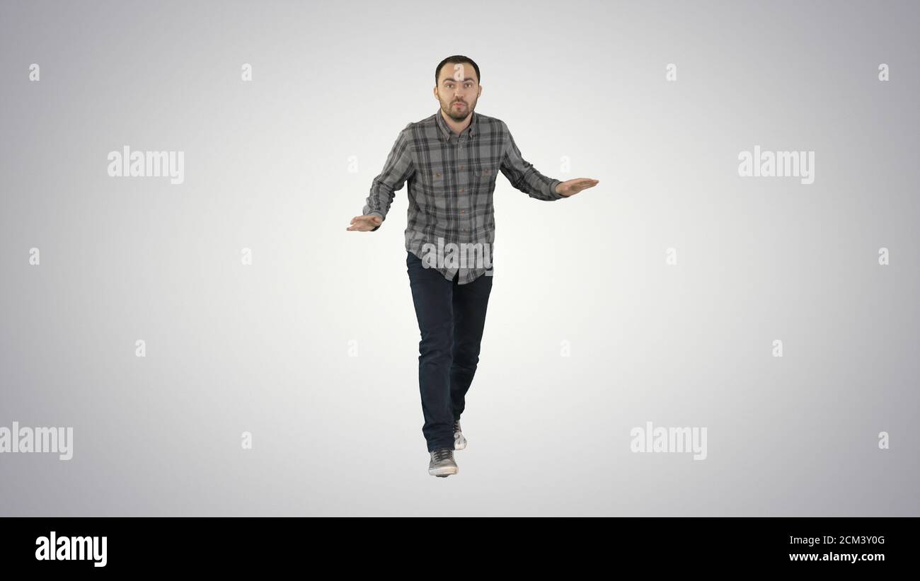 Young man in a casual outfit walking and dancing on gradient bac Stock Photo