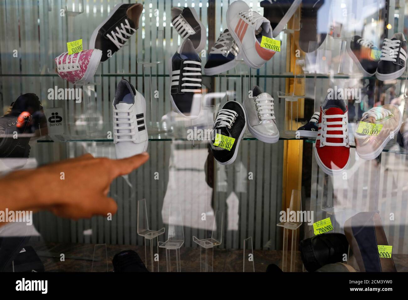 A man points at prices in a shoes store display window in downtown Caracas,  Venezuela January 9, 2018. REUTERS/Marco Bello Stock Photo - Alamy