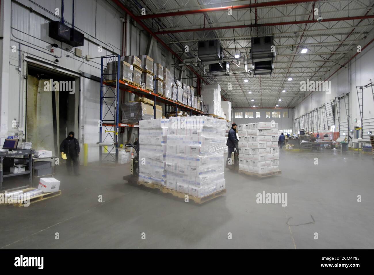 A Forklift Operator Moves A Pallet Of Imported Frozen Seafood From China Inside The Refrigerated Warehouse