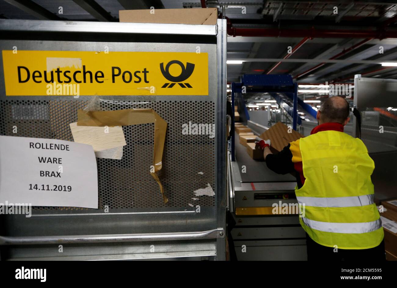 An employee puts parcels on a conveyor belt at a new DHL/Deutsche Post  parcel center in Bochum, Germany, November 18, 2019. REUTERS/Leon Kuegeler  Stock Photo - Alamy