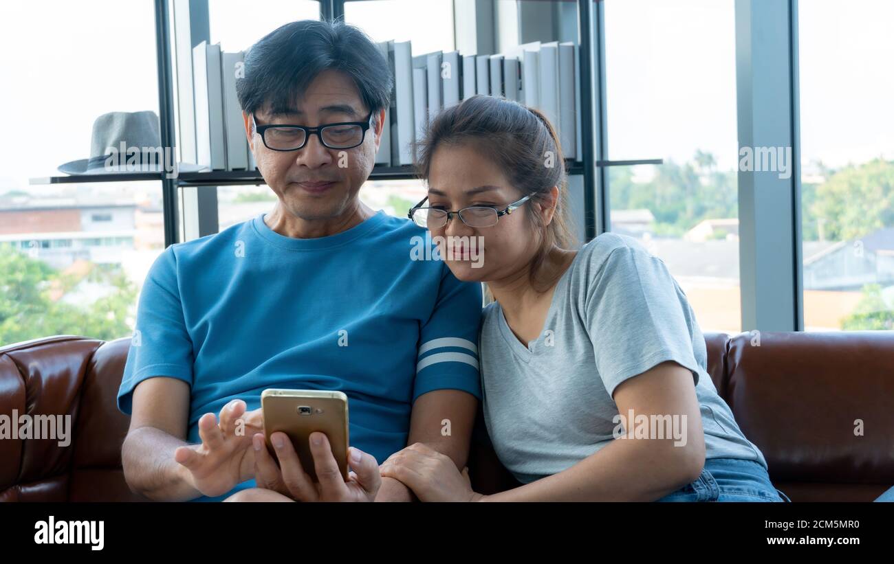 Old man and woman playing videogame at home Stock Photo