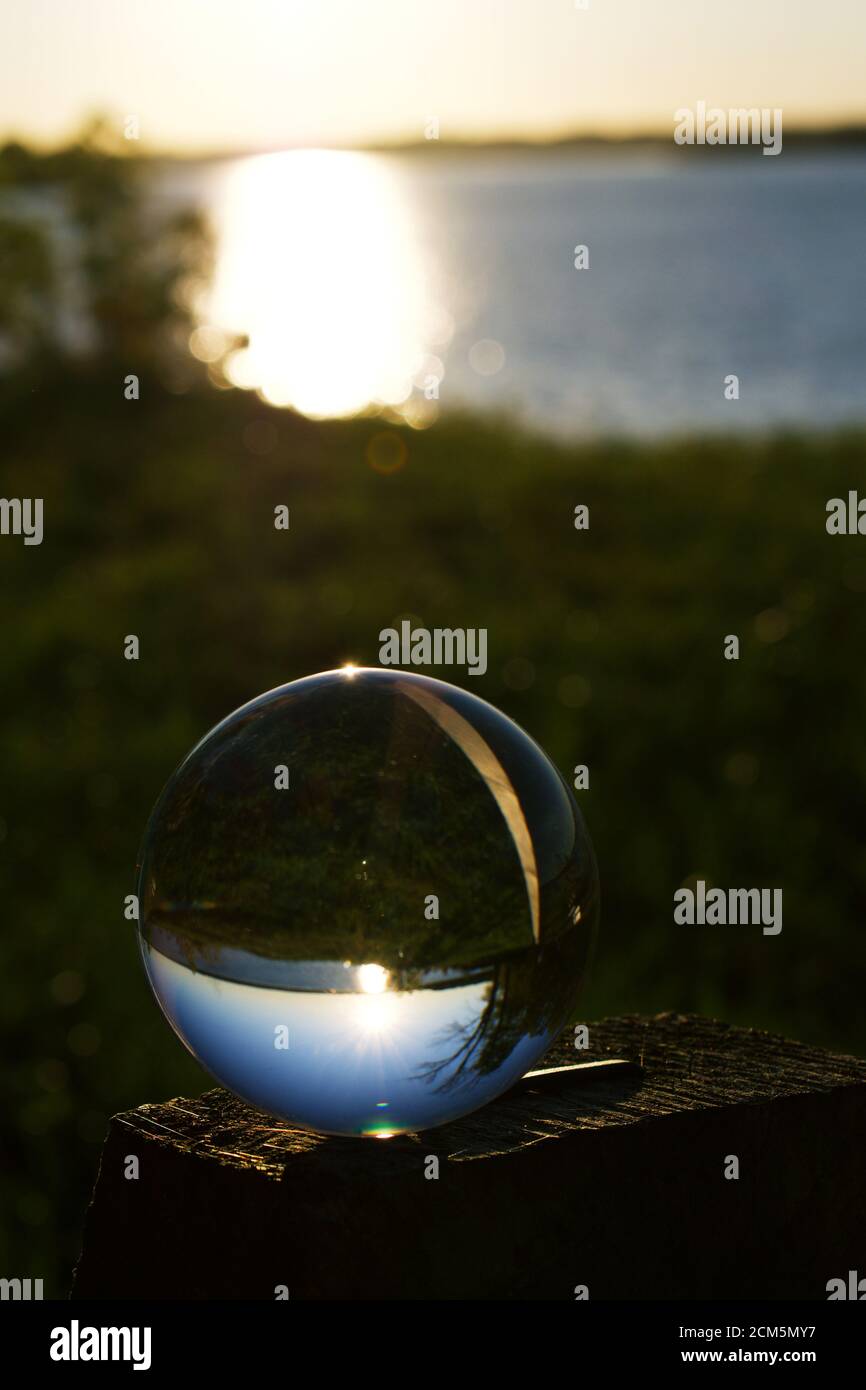 Reflection of sunset over water in a crystal ball Stock Photo - Alamy